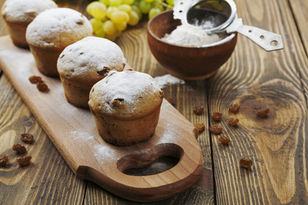 Homemade muffins with raisins and powdered sugar on the tableの写真素材