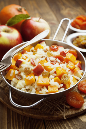 Sweet pilaf with pumpkin, apples and dried fruit on the tableの写真素材