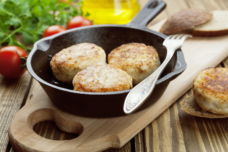 Burger in the frying pan on the wooden table
