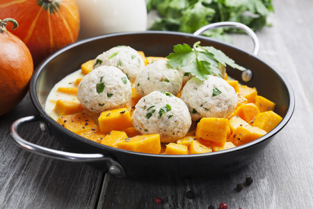 Baked pumpkin and chicken meatballs with herbs in a saucepanの写真素材