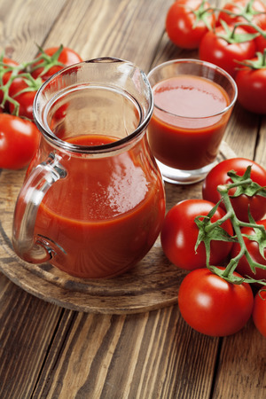 Tomato juice in a glass jar on a wooden tableの写真素材