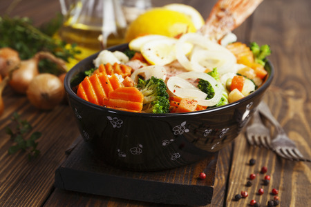 Fried fish with vegetables in the  potの写真素材