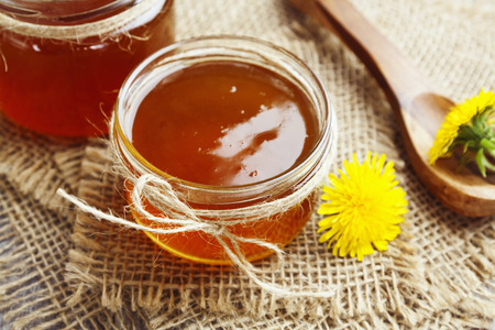 Jelly of dandelions in a glass jar on the tableの写真素材