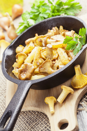 Fried potatoes with chanterelles in a frying pan on the tableの写真素材