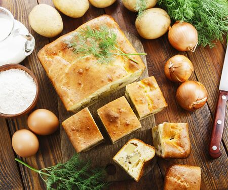 Pie with potatoes and dill on the tableの写真素材