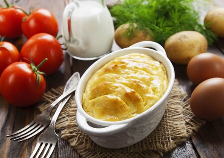 Potato casserole with meat on the wooden tableの写真素材