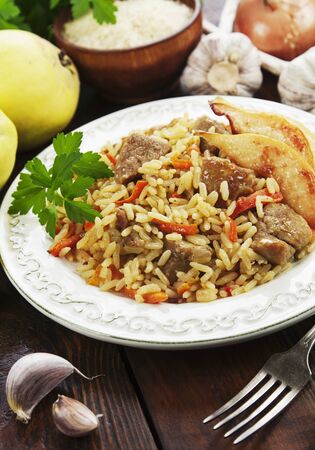 Pilaf with meat and quince on the tableの写真素材