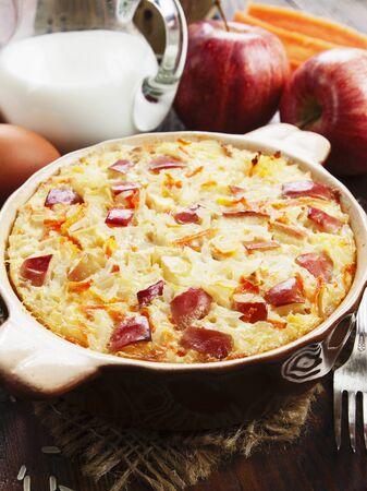 Rice pudding with apples and carrots on the tableの写真素材