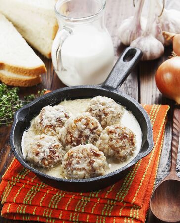 Meatballs with rice in a creamy sauce on the tableの写真素材