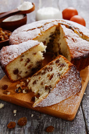 Cake with raisin and sugar powder on the wooden table