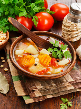 Pea soup with tomatoes in a bowl on the tableの写真素材