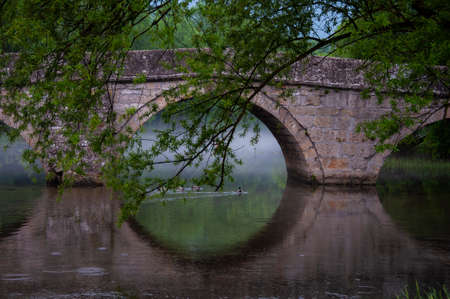Roman bridge reflection on river Bosna surraonded by nature on a sunny dayの写真素材