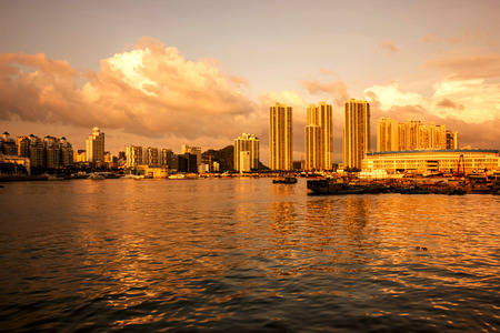 The setting sun illuminates the sea and the city