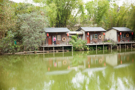 Woman at a chalet fishing by the riverのeditorial素材