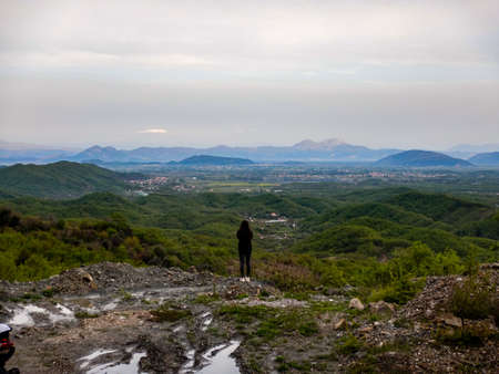 A man stands on the edge of a mountain and looks at the horizon.