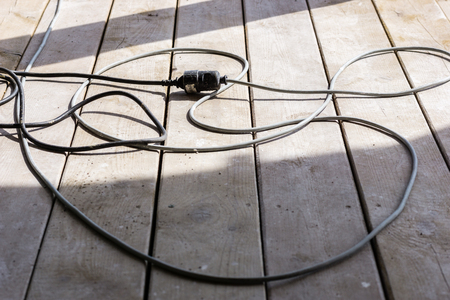 electrical cable extension plug in construction site on the wood plank backgroundの写真素材