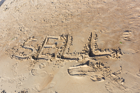 Sell written in the sand on a sunset beach. Summer beach writingsの写真素材
