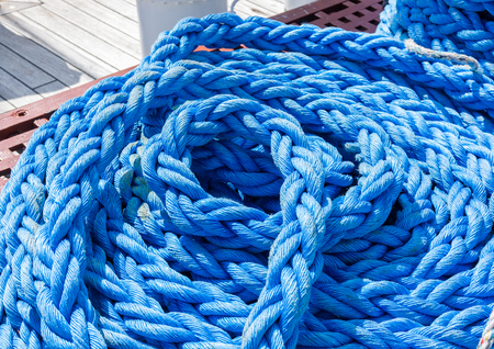 Rope on a sailing boat laying on the wooden plank ground