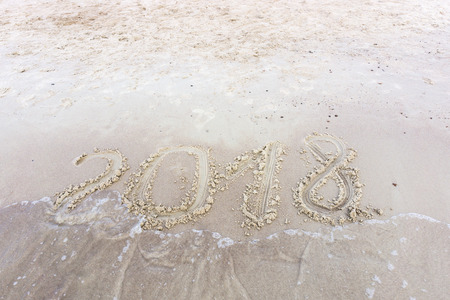 2018 written in the sand on a sunset beach. New yearの写真素材