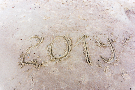 2019 written in the sand on a sunset beach. New yearの写真素材