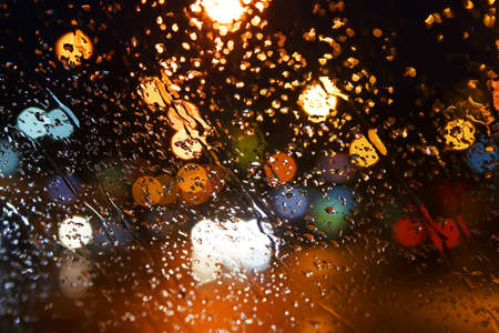 Rain drops on the window. Bokeh night city.の写真素材