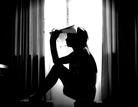 The silhouette of stressed and depressed woman worried about her studiesの写真素材