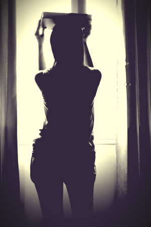 The silhouette of stressed and depressed woman worried about her studiesの写真素材