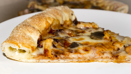 Piece of pizza with cheese edges on white backgroundの写真素材