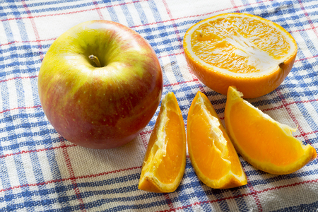 Apple and orange slices on tableclothの写真素材