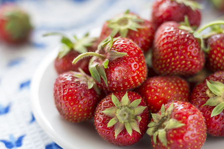Juicy ripe strawberry on a white plateの写真素材