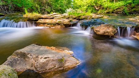 At the Felsenbad, a natural water pool with small waterfalls at lake Schussen in Upper Swabia