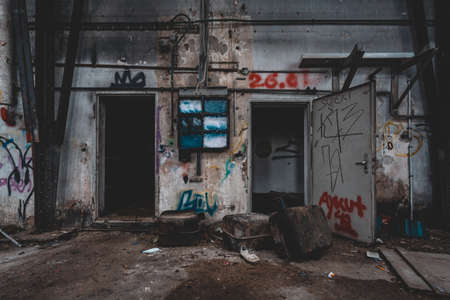 An old abandoned industrial area, with lots of graffiti that is slowly falling apart