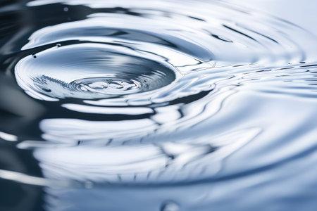 close up of water drop splashing and rippling on surfaceの素材