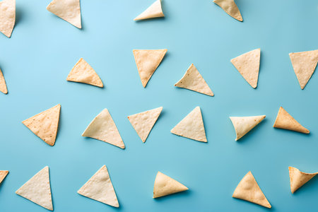 Tortilla chips pattern on blue background. Flat lay, top viewの素材