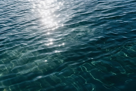 Blue sea water surface with sunbeams and reflection in the waterの素材