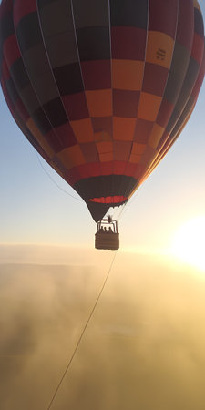Hot air balloon flying over the clouds at sunrise. 3d renderの素材