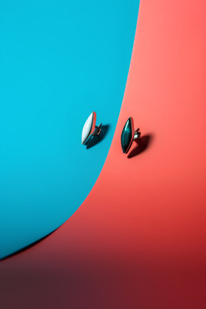 Fashionable earrings on a red and blue background. Minimal style.の素材
