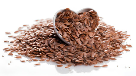Flax seeds in a heart-shaped bowl on a white backgroundの素材