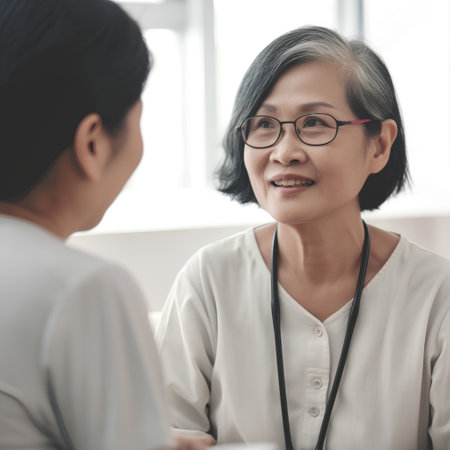 Asian senior female doctor talking to her female patient at the hospital.の素材