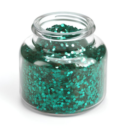 Green sequins in a glass jar isolated on a white background.の素材