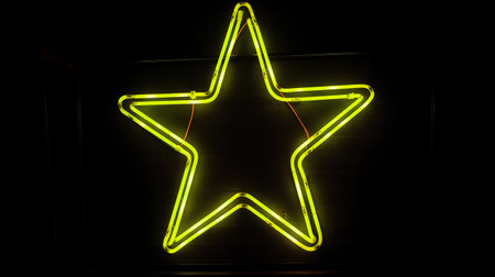 Neon star sign on a black background. Illuminated neon star.の素材