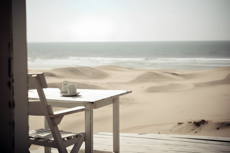 Cup of coffee on a wooden table in the sand dunesの素材
