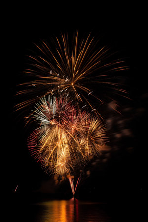 Colorful fireworks of various colors over night sky with reflection on waterの素材