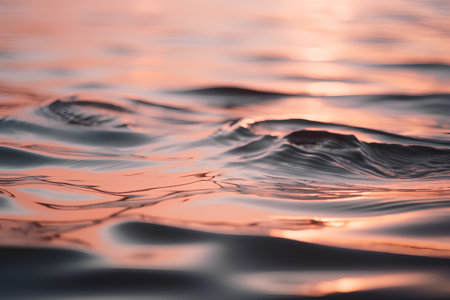 abstract background of water surface with waves and ripples at sunsetの素材
