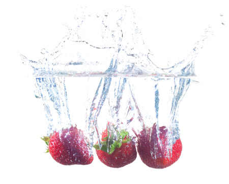 Ripe Strawberries Dropping Into Waterの写真素材