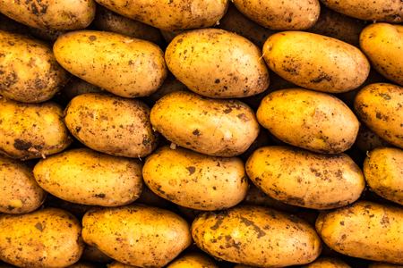 Stack of potatoes at a vegetable marketの写真素材