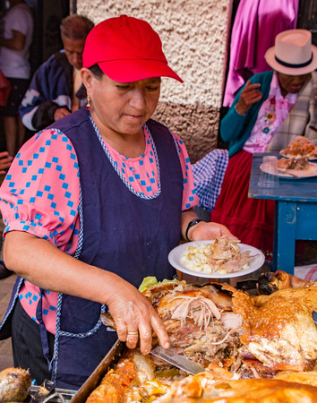 San Bartolome, Ecuador Aug 24, 2017 - Vendor prepares Hornado (pig) lunch for customerのeditorial素材