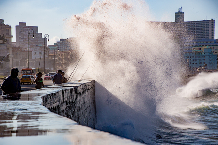Havana, Cuba, Nov 20, 2017 - Waves crash over the Malecon wall as men continue to surf fishのeditorial素材