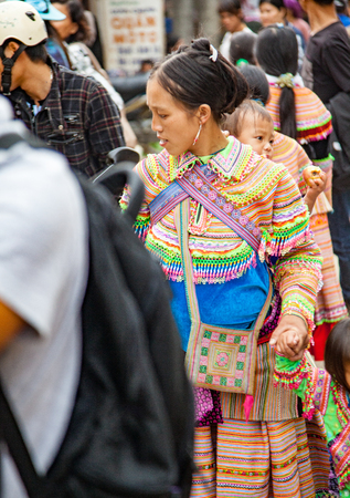 North Vietnam - Oct 22, 2011:   woman in colorful native clothing with child on her backのeditorial素材