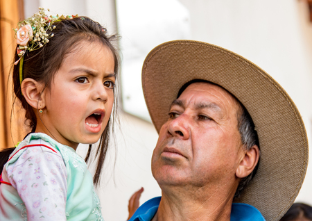 Cuenca, Ecuador Dec 24, 2017 - Father reacts to unhappy daughter, who is dressed for the annual Pase de Nino Christmas paradeのeditorial素材